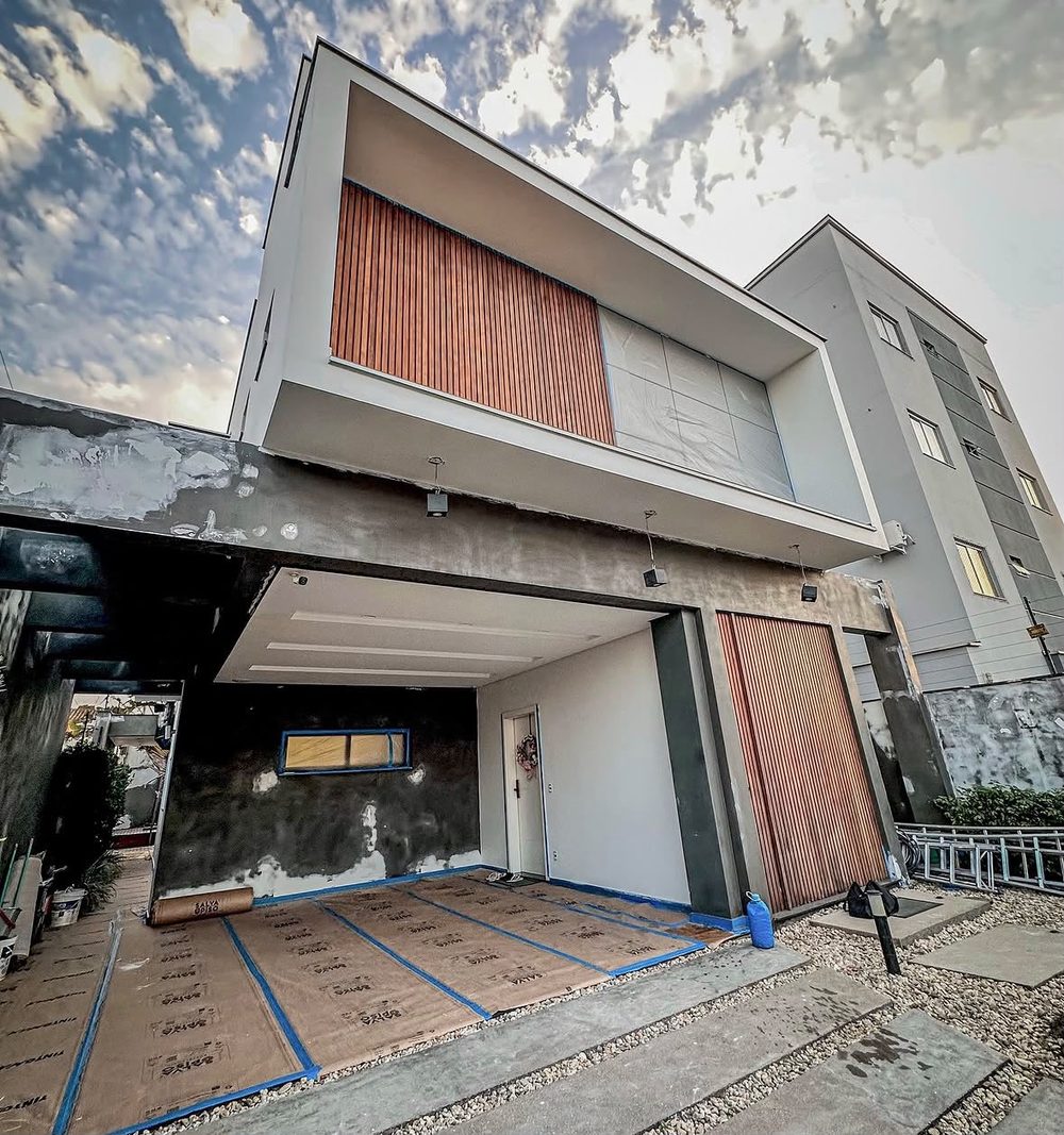 Fachada residencial antes da reforma: reboco cru, sem pintura, obra em andamento