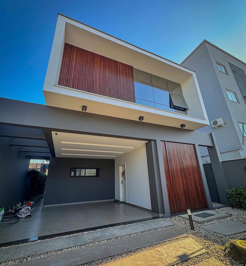 Mesma fachada residencial depois: pintura completa, acabamento em madeira e área externa pronta