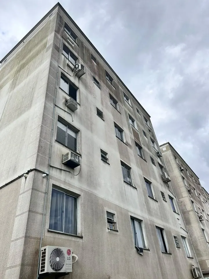 Prédio residencial de cinco andares com a fachada encardida e manchada de sujeira