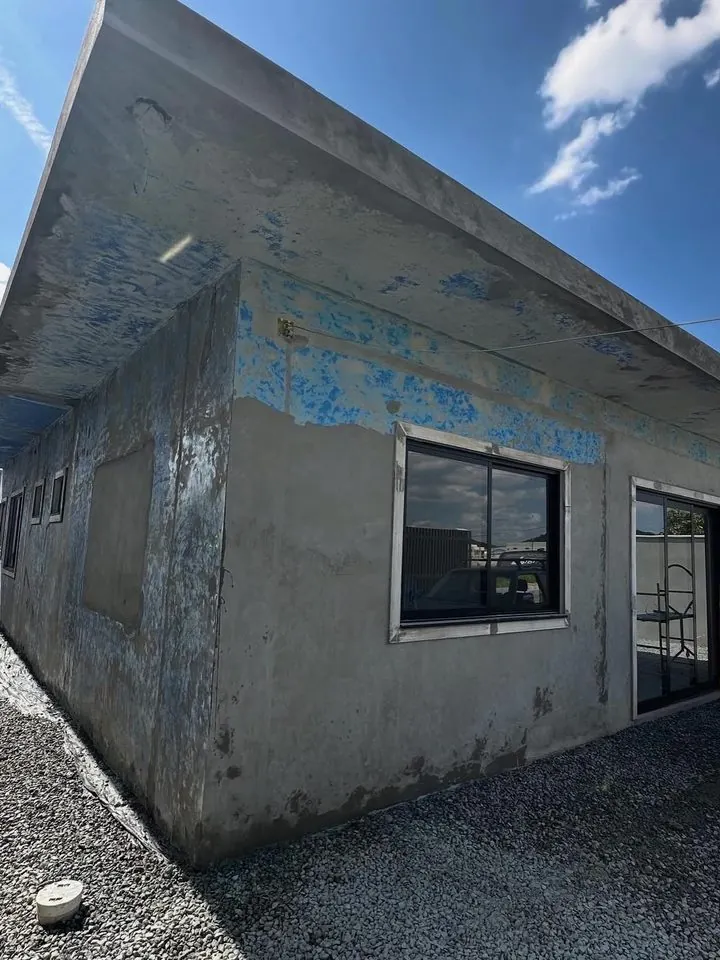 Casa térrea em concreto aparente, com manchas e restos de tinta antes da aplicação