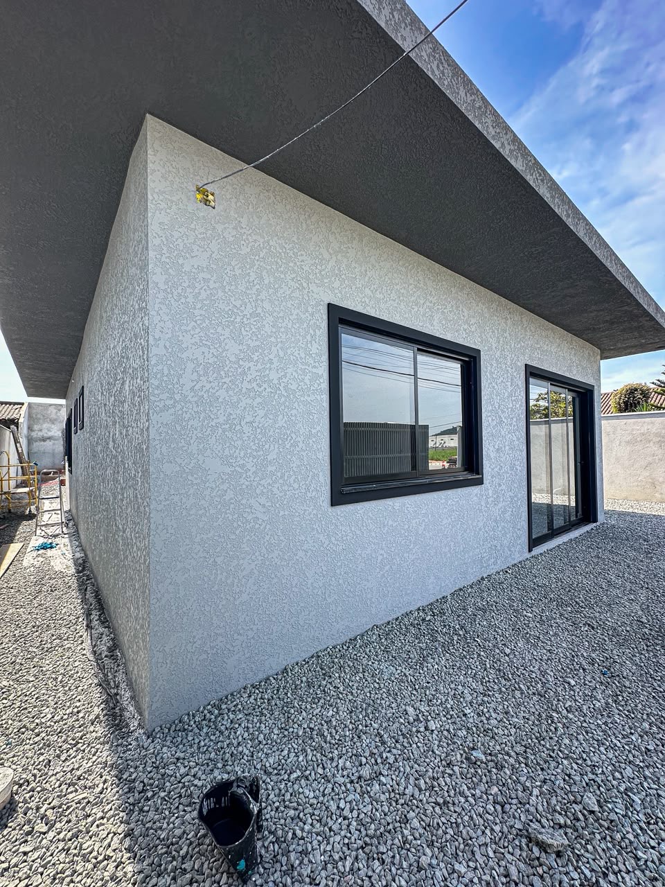 Fachada de casa térrea com textura projetada em cinza claro