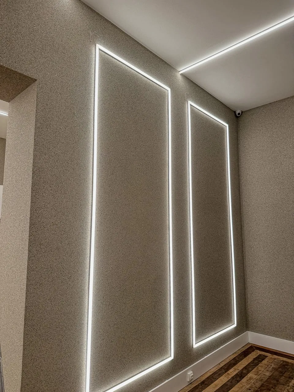 Parede com acabamento em textura riscada tipo grafiato, iluminação embutida em canaleta
