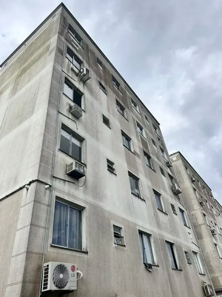 Prédio residencial de cinco andares com a fachada encardida e manchada de sujeira