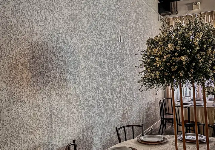 Parede interna de salão de eventos com textura projetada em tom claro