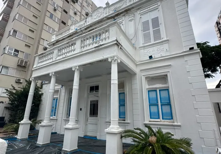 Fachada de casarão histórico restaurada, com detalhes de moldura em madeira